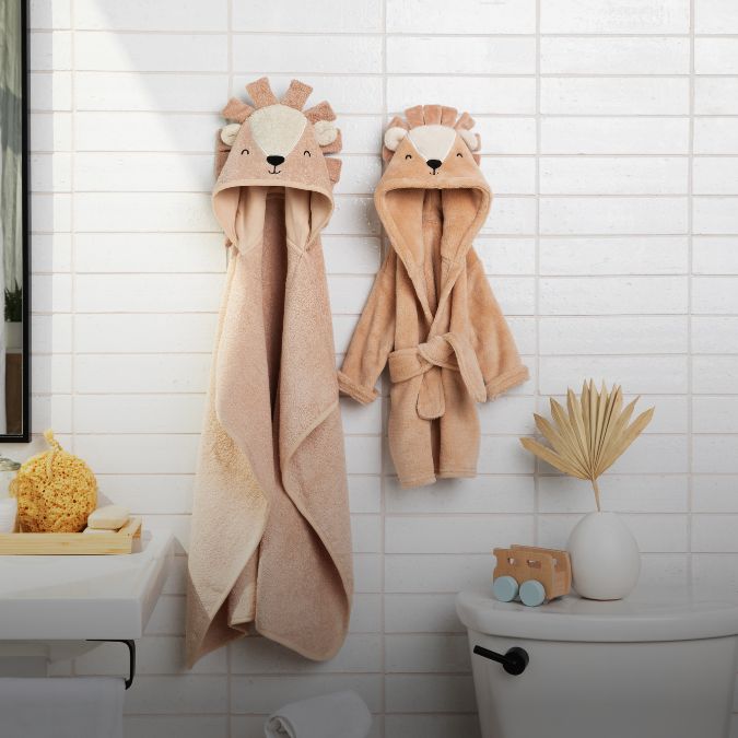 A bathroom with a lion towel hanging on the wall.