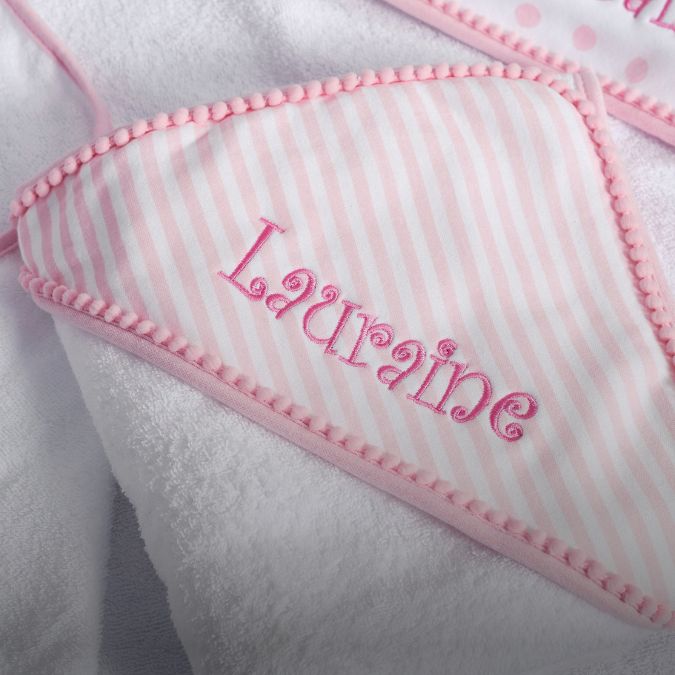 A pink and white striped towel with an embroidered name on it.