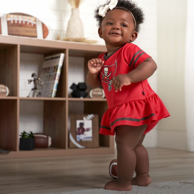 A baby girl wearing a Tampa Bay Buccaneers cheerleader dress.
