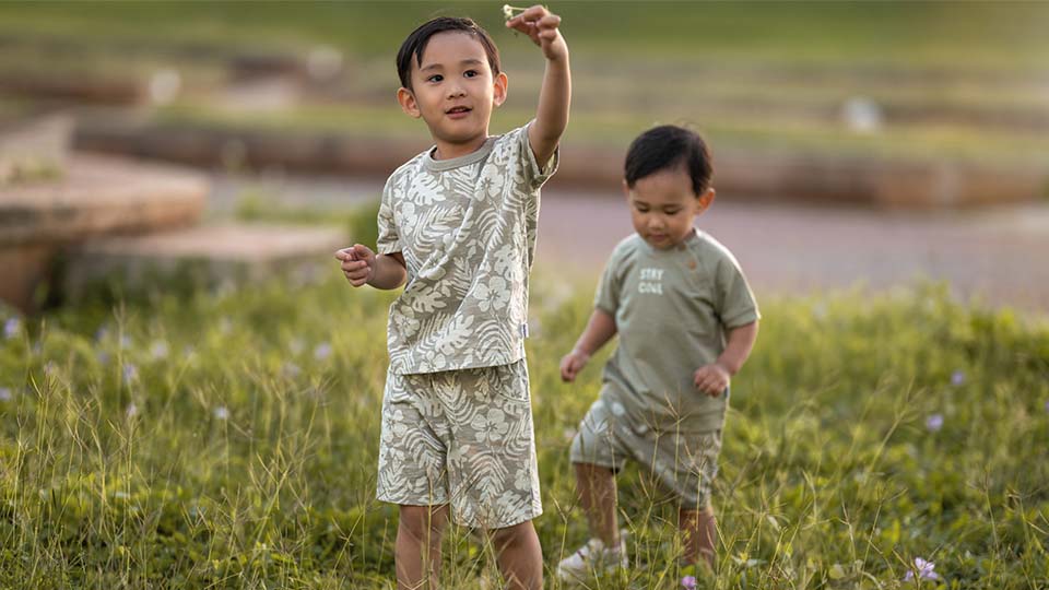 Brothers in a field wearing cute matching outfits.