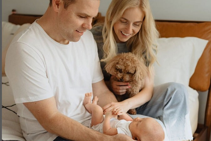 Happy young parents looking and touching their newborn baby.
