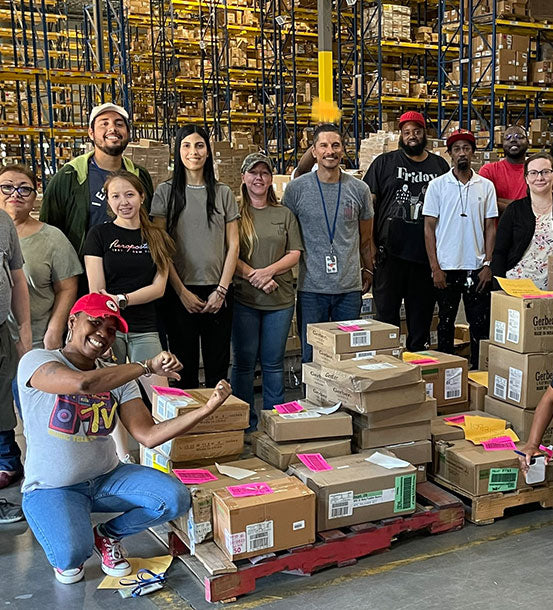 People in the Gerber warehouse smiling and standing near boxes.