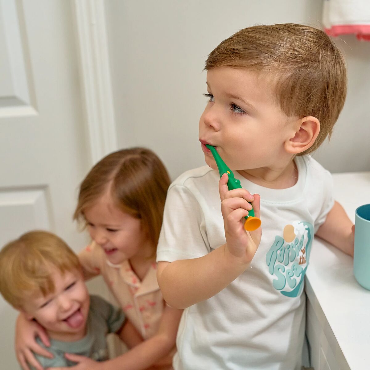 Child playing with a toy toothbrush in a bathroom setting