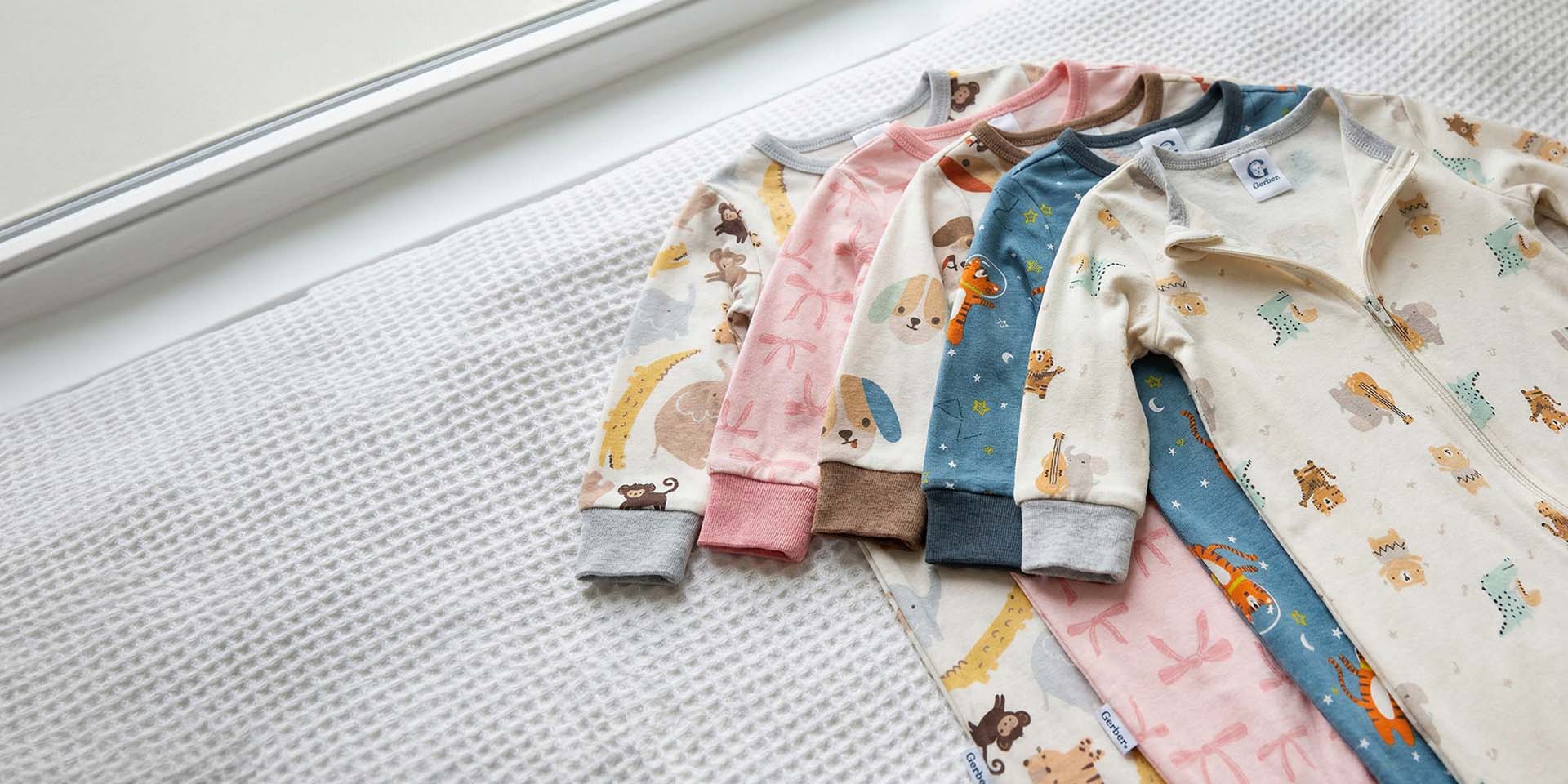 Set of children's pajamas with animal patterns on a textured surface