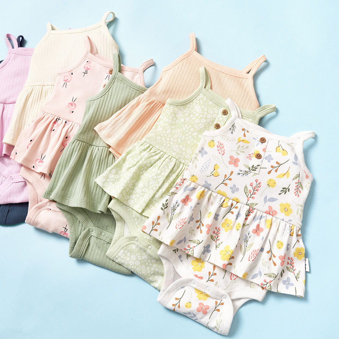 Collection of baby bodysuits in various patterns on a light blue background