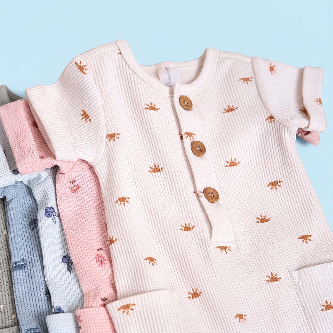 Baby rompers with sun pattern on a light blue background