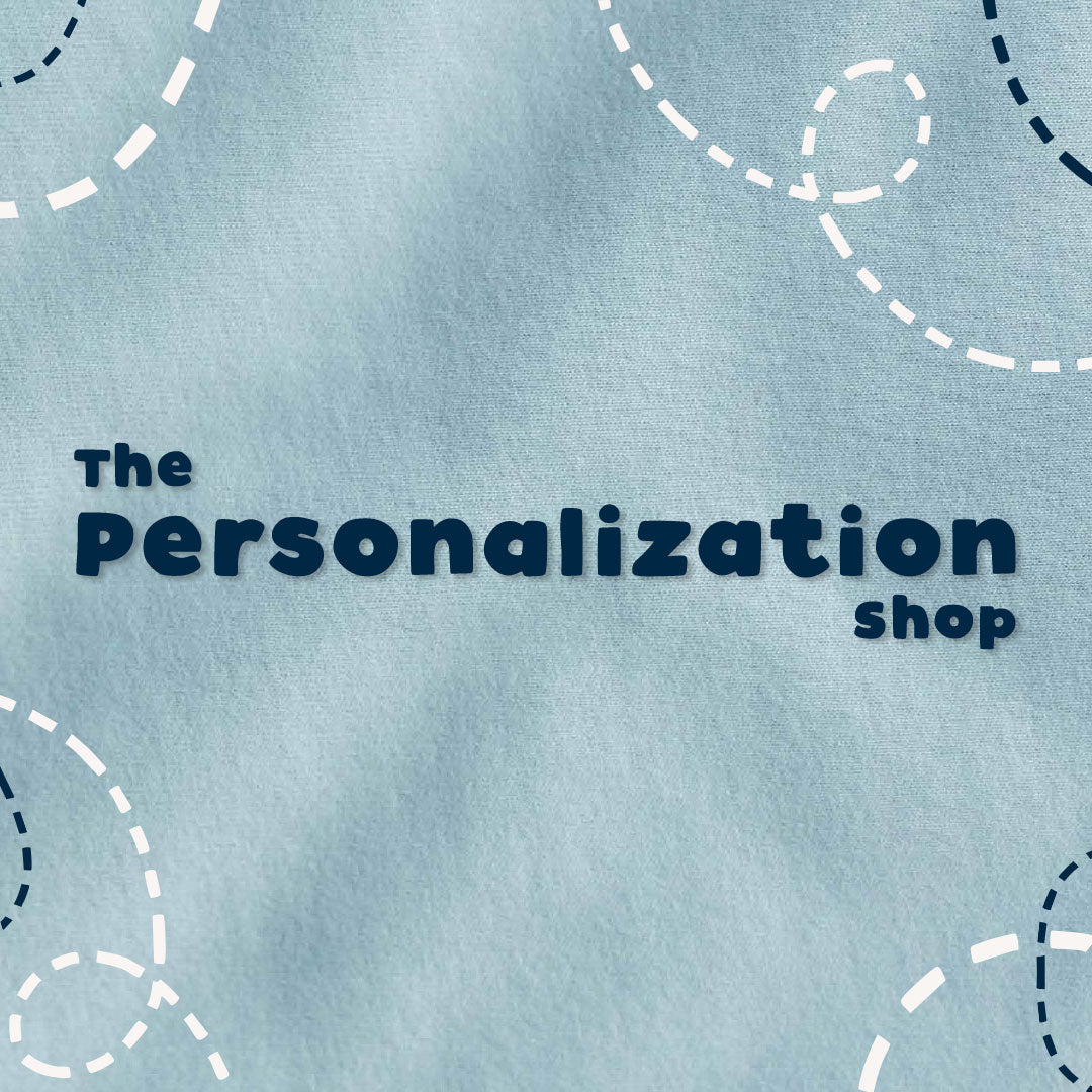 A light blue textured fabric background with the words 'The Personalization shop' in dark navy text, surrounded by dashed circular line illustrations in white and navy.
