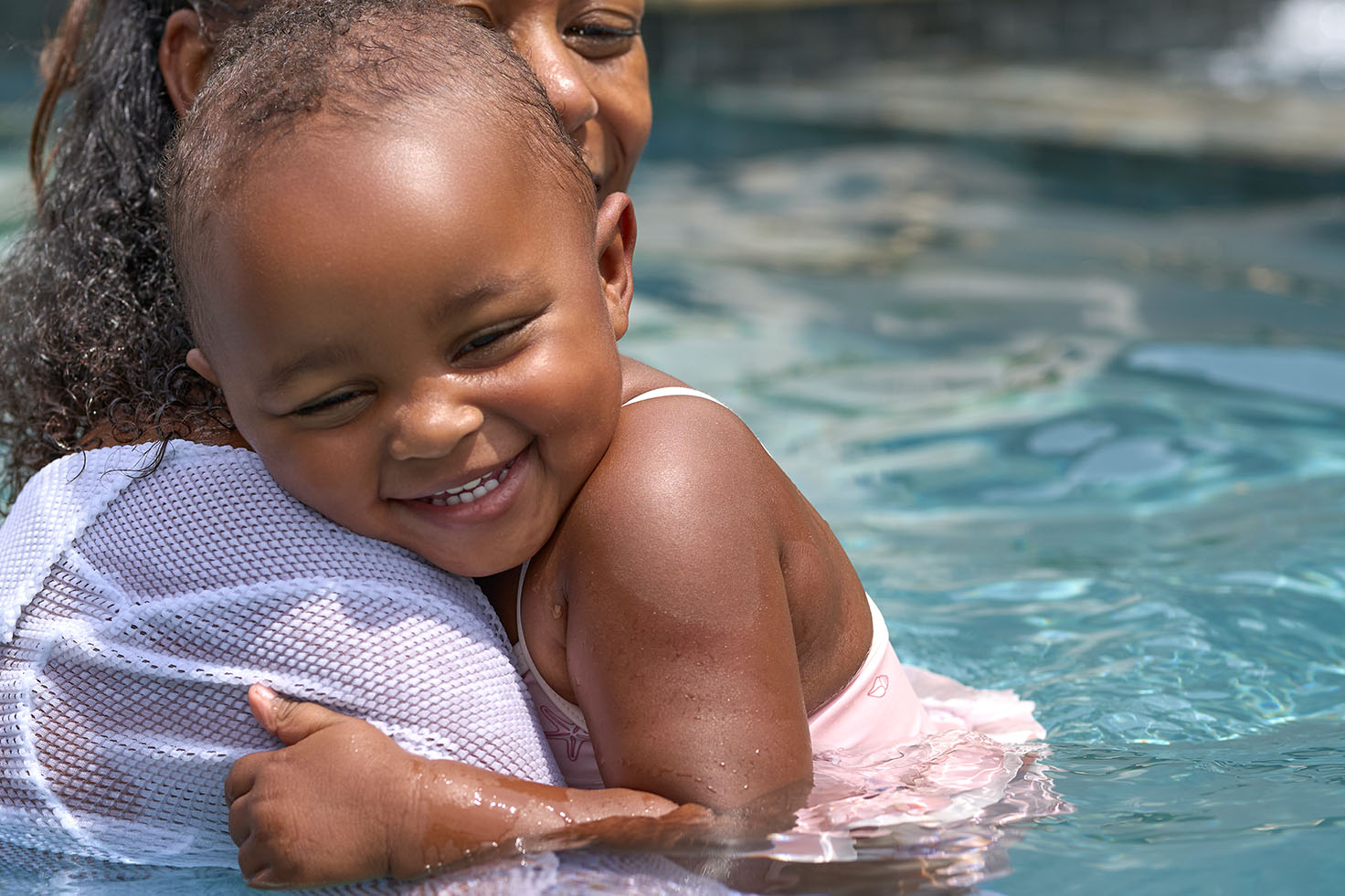 Woman and child embracing in a pool