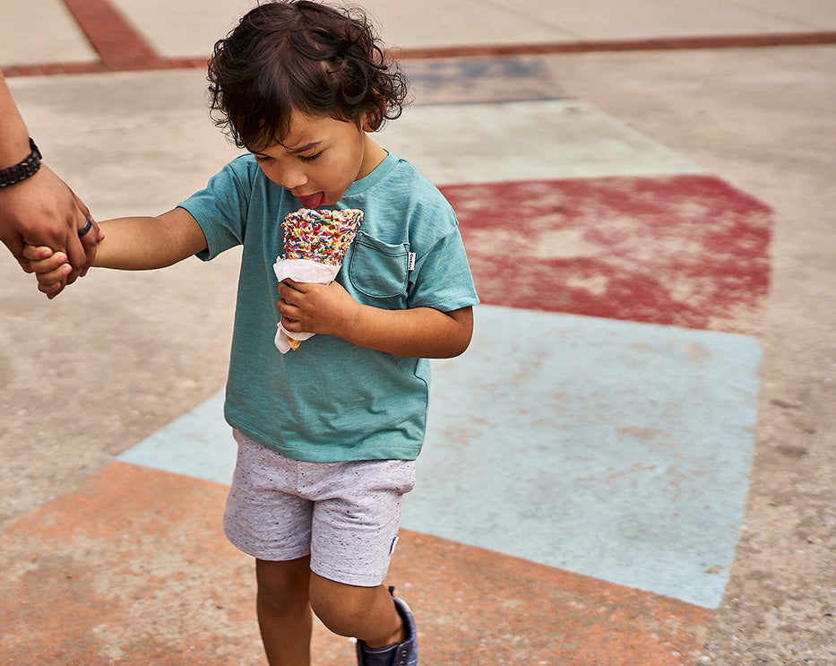 Child holding a colorful ice cream cone on a playground