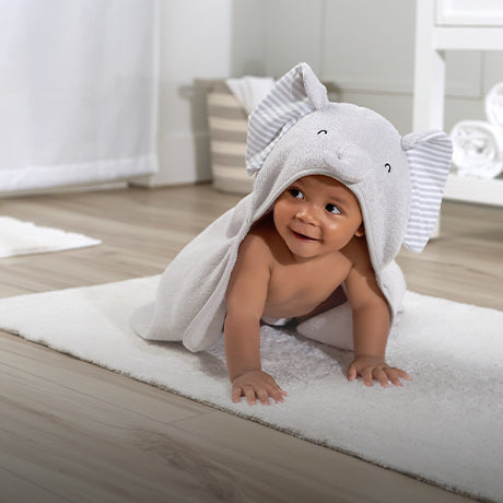 Baby crawling on floor in a towel.