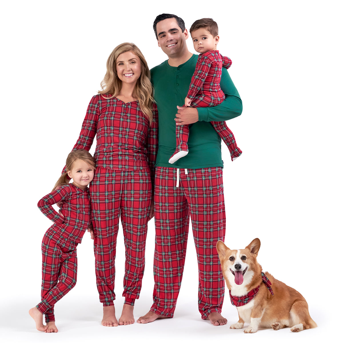 A heartwarming image capturing a family and their dog, all clad in red and green plaid pajamas, enjoying the holiday season in their Christmas-themed sleepwear.