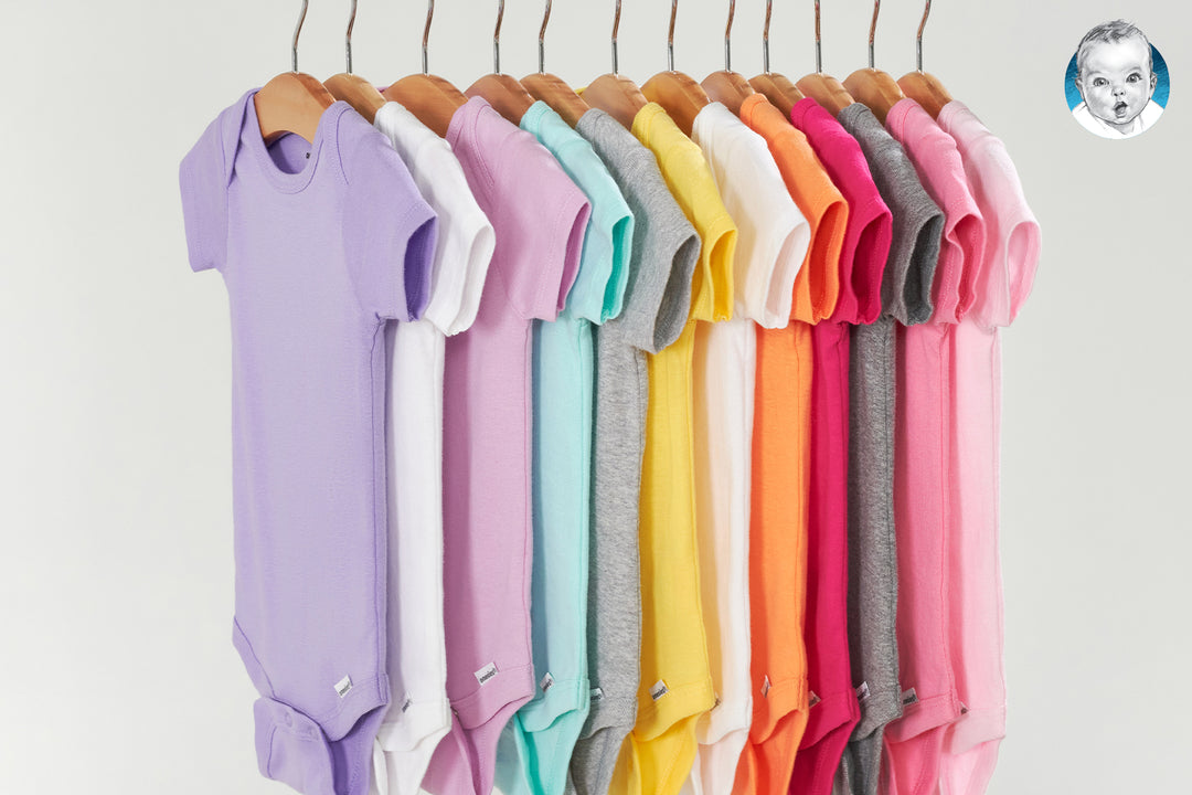 Colorful bodysuits in a row hanging up on a rod.