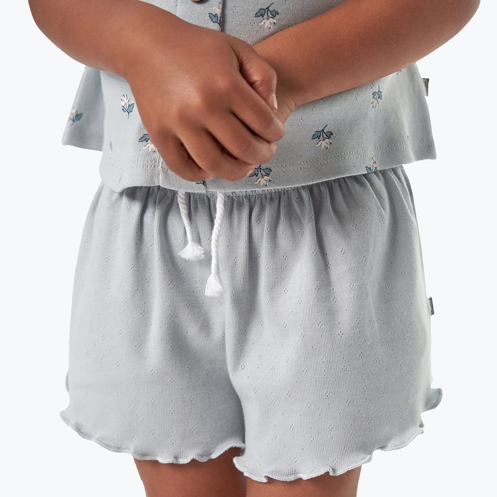 Light gray shorts with a subtle pattern worn by a person on a white background