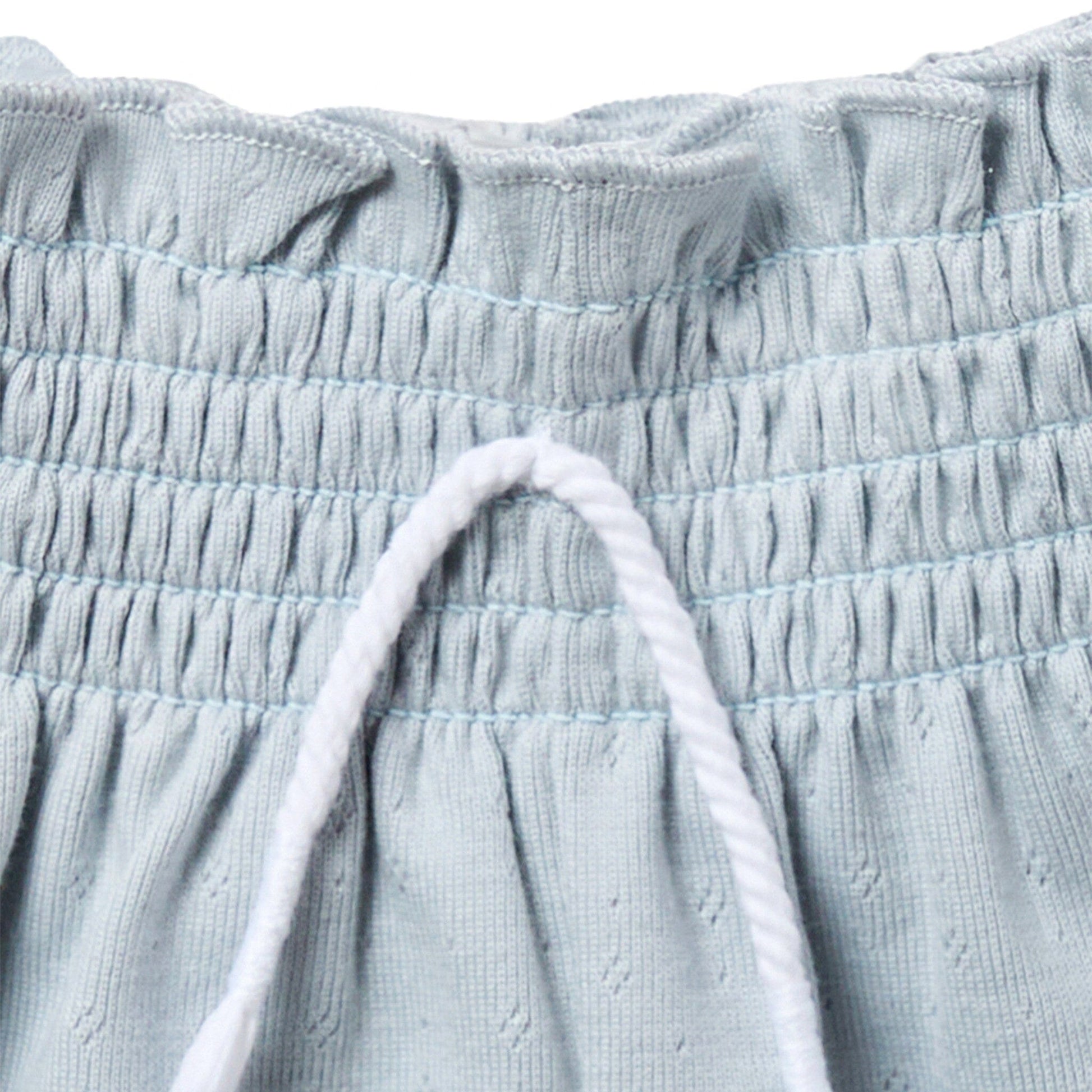 Close-up of light blue textured fabric with drawstring