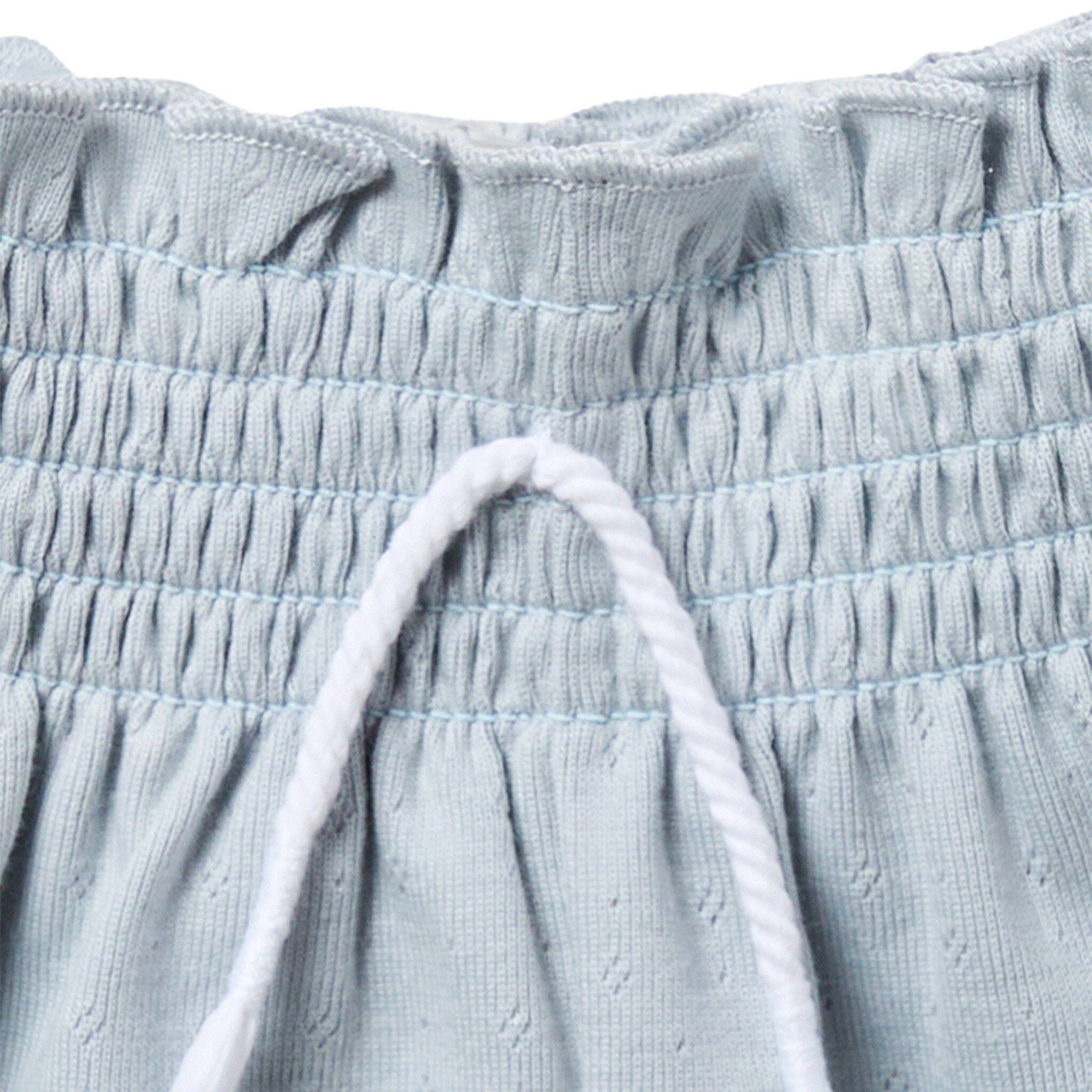 Close-up of light blue textured fabric with drawstring