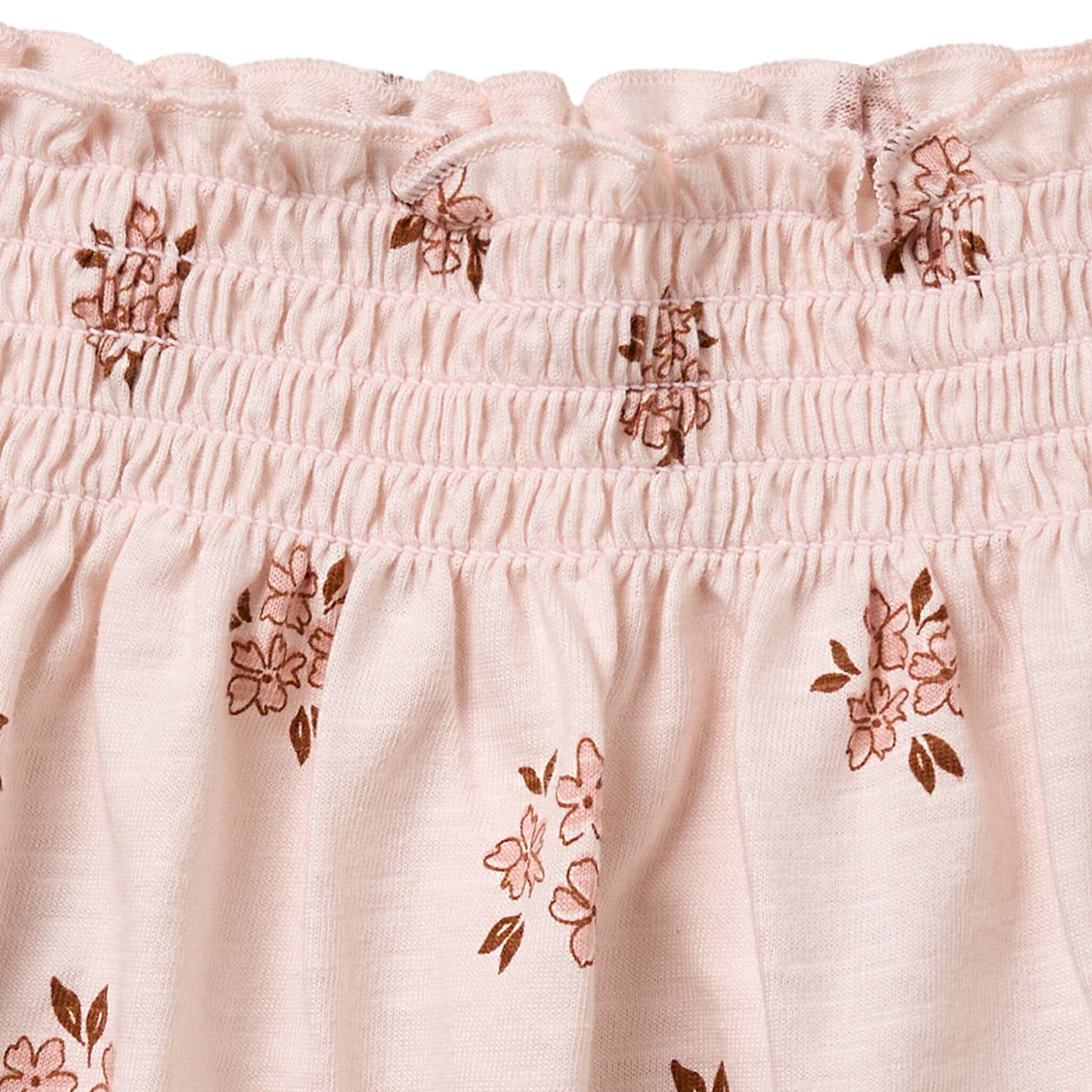 Close-up of a pink fabric with floral embroidery