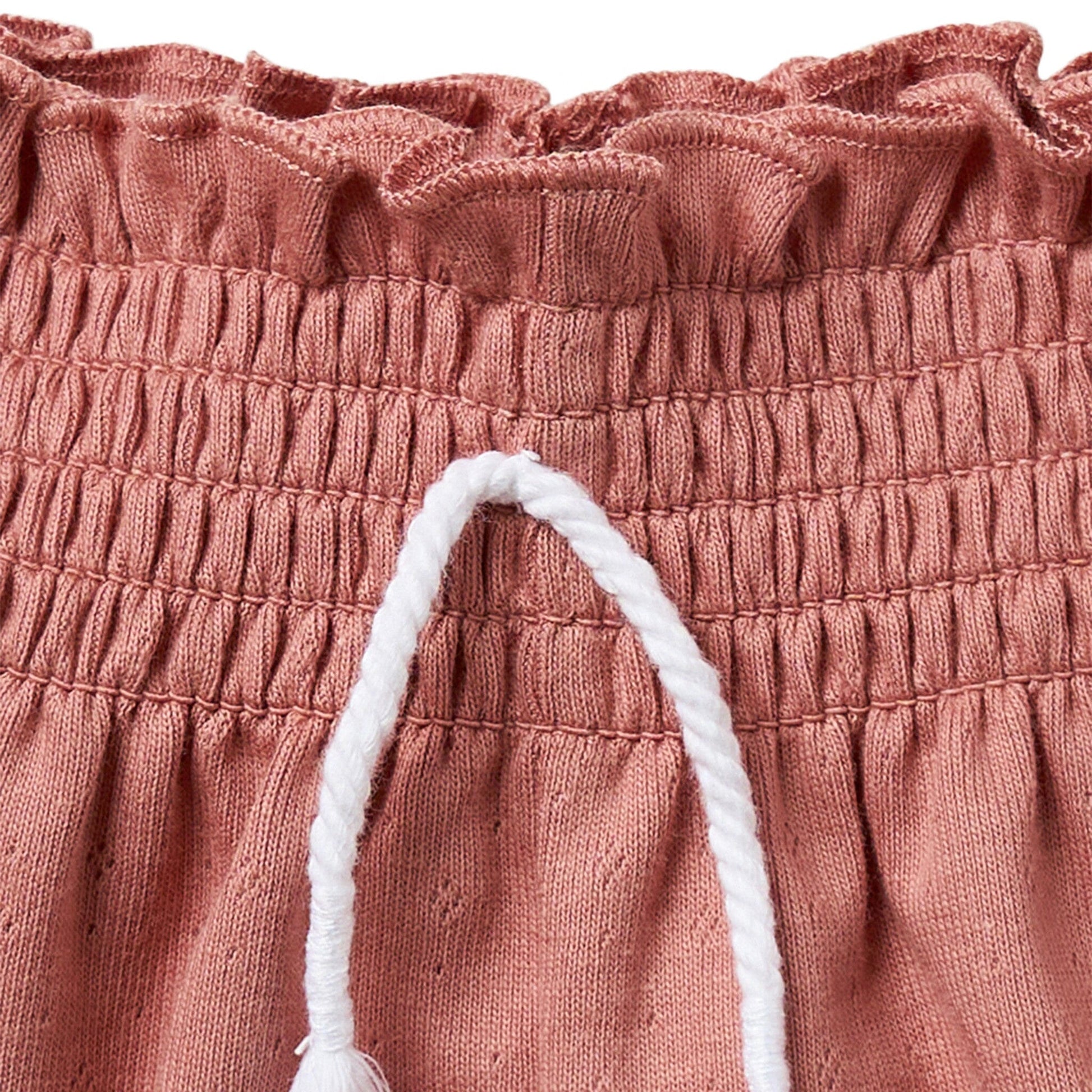Close-up of pink textured fabric with white trim