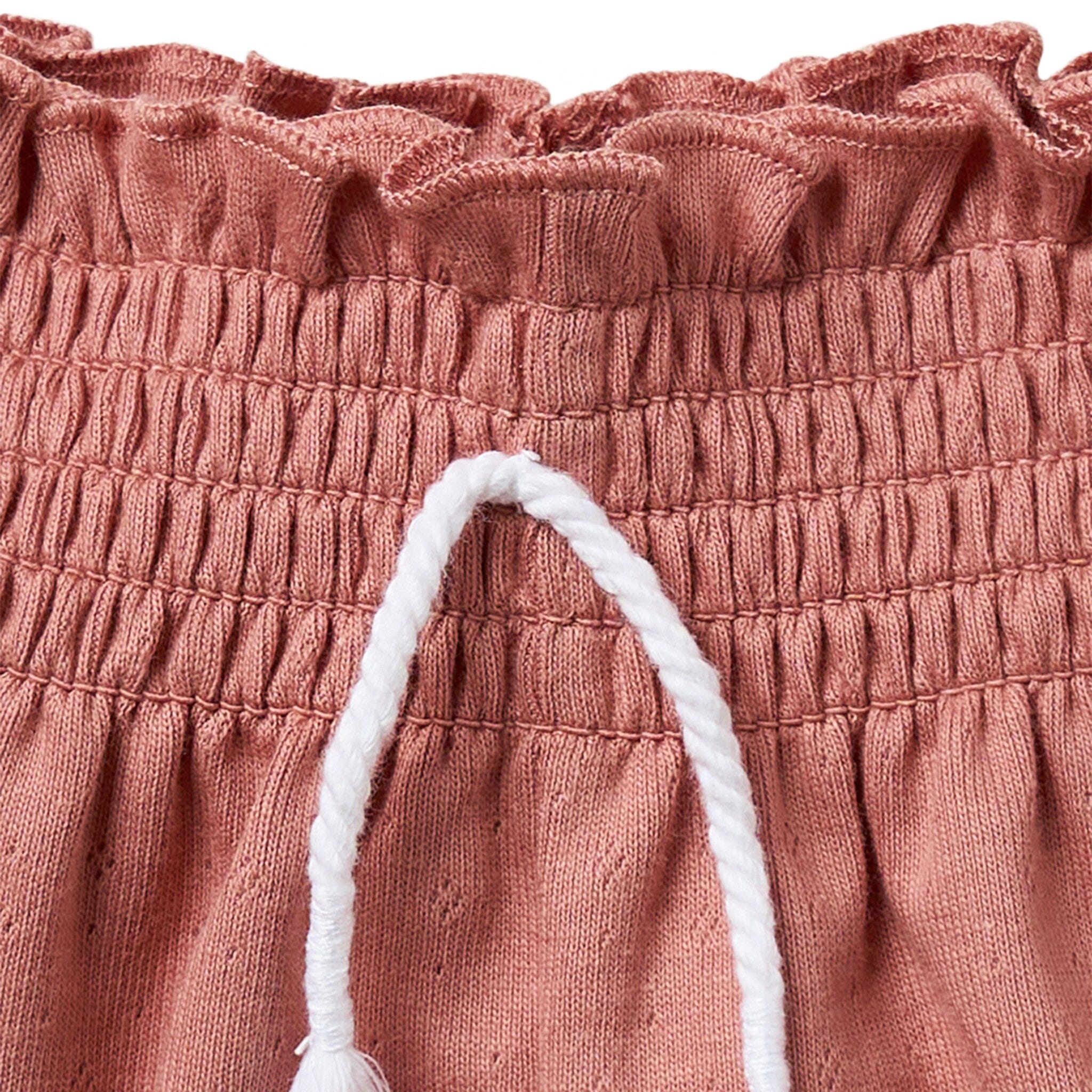 Close-up of pink textured fabric with white trim