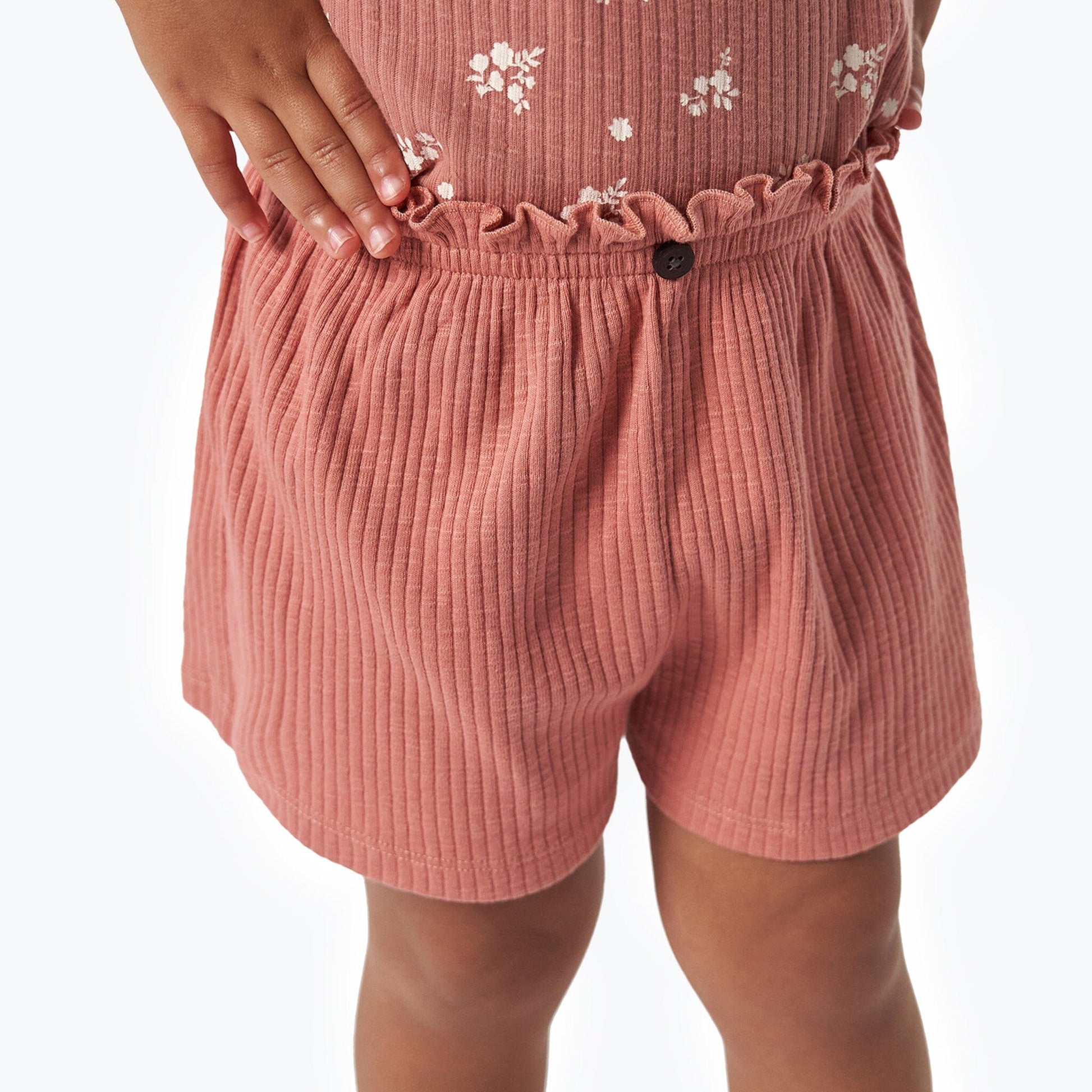 Pink ribbed shorts with a button on a white background
