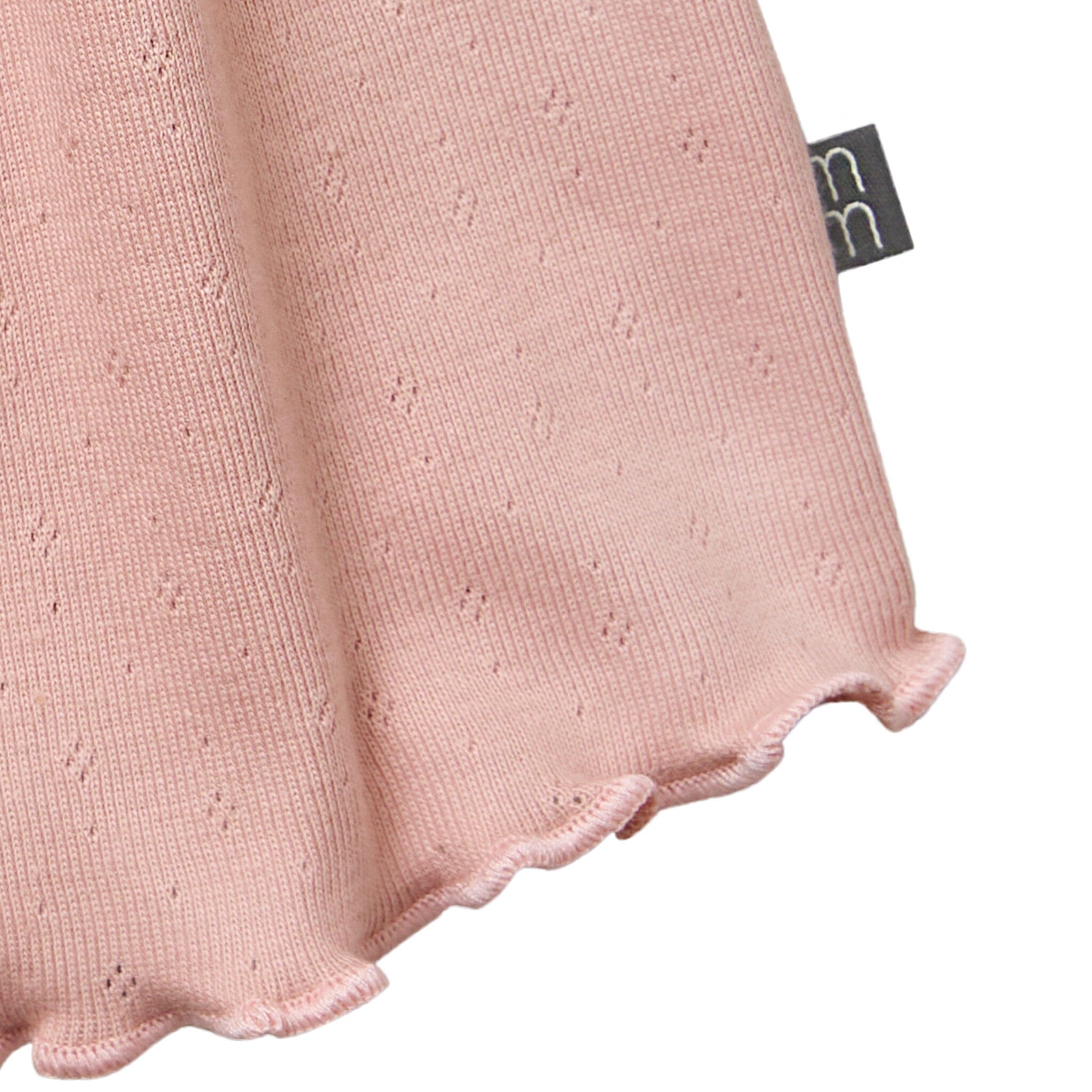 Close-up of a pink textured fabric with a brand tag on a white background