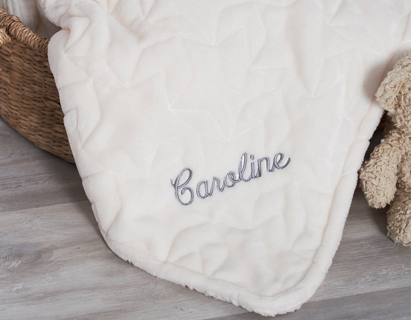 A soft, personalised baby blanket featuring the name "Caroline" embroidered in elegant script. Perfect for snuggles and naps.